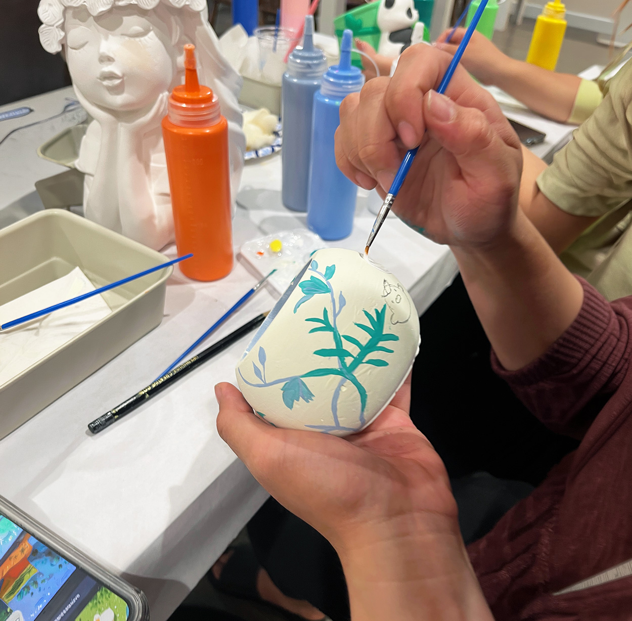 Child painting a ceramic piece