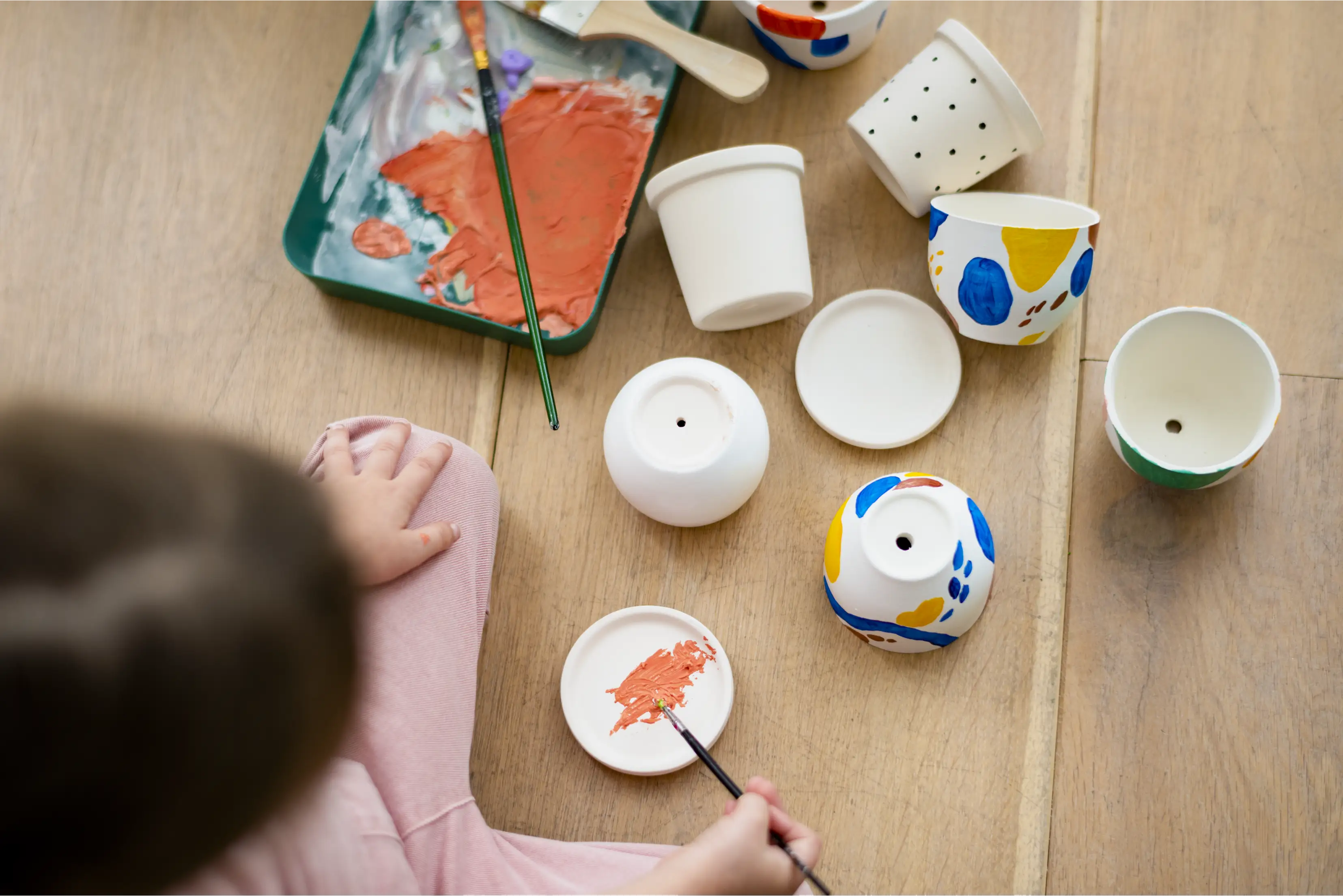 Child painting a ceramic piece