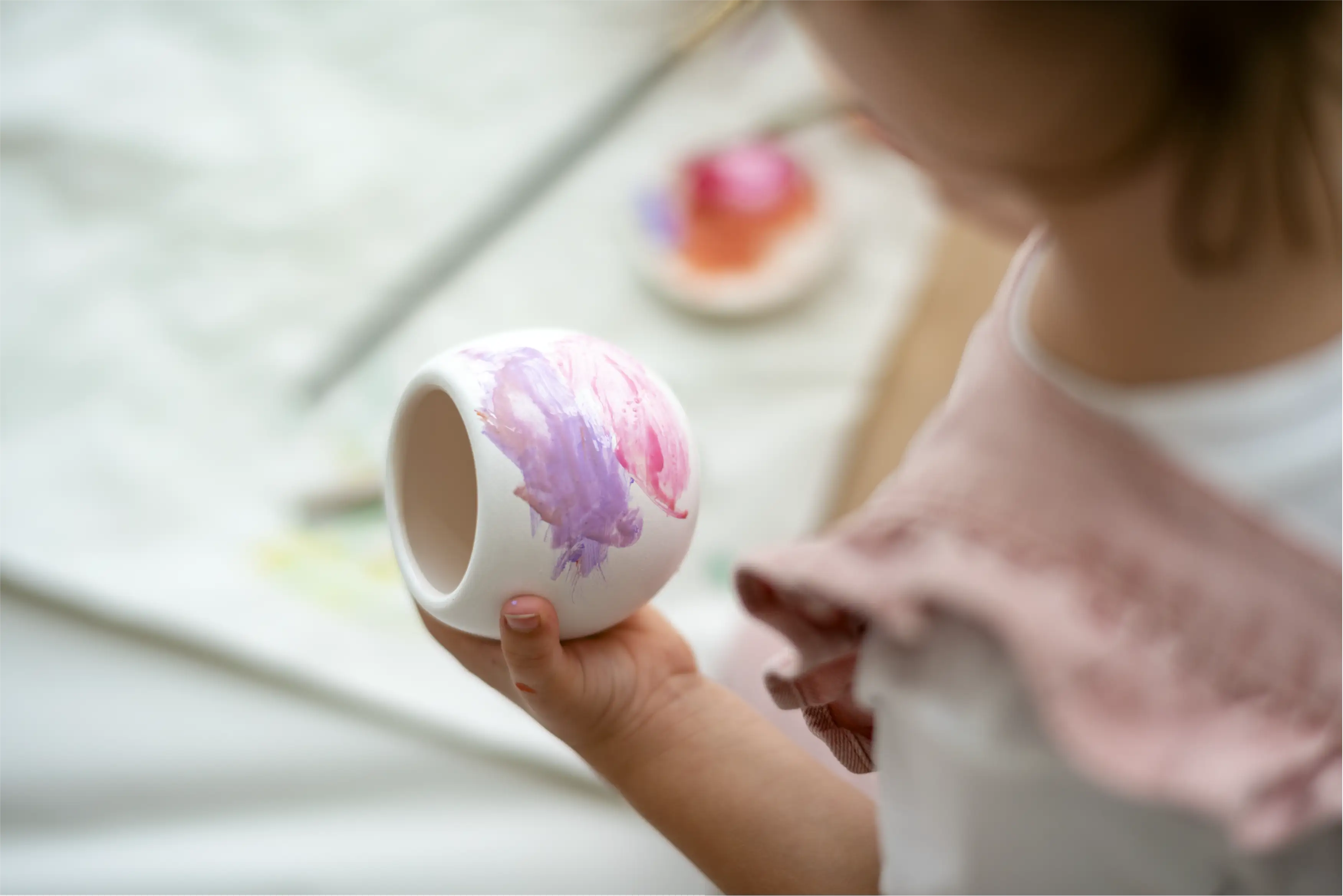 Child painting a ceramic piece