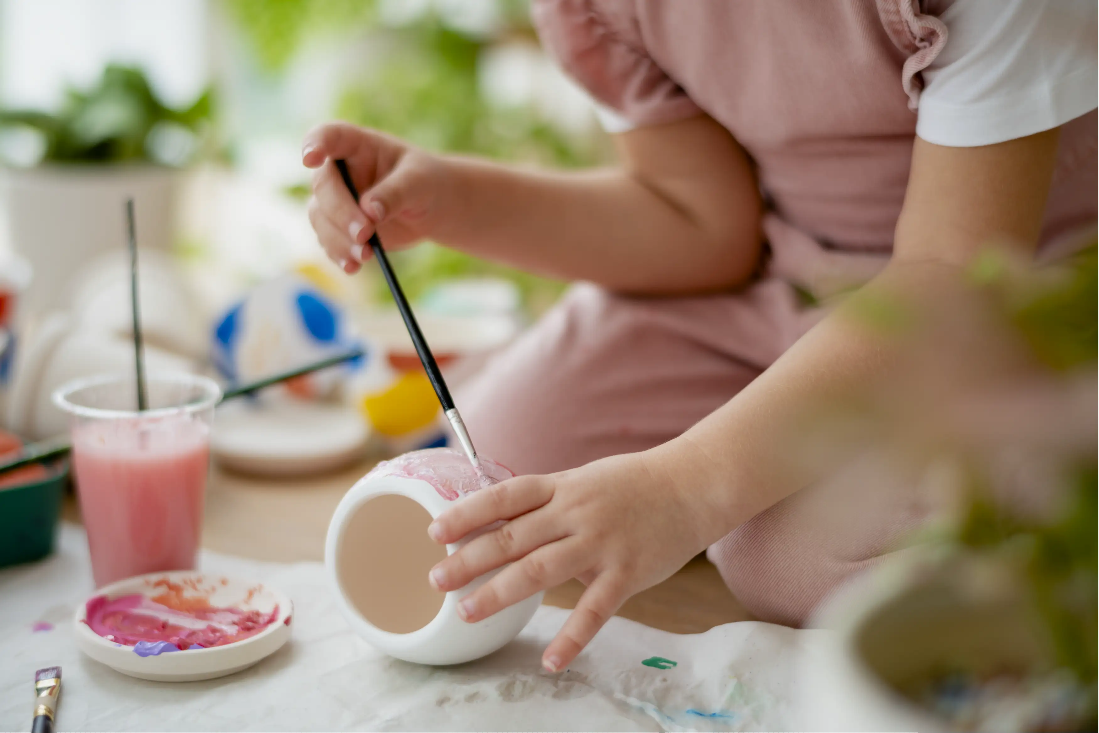 Child painting a ceramic piece